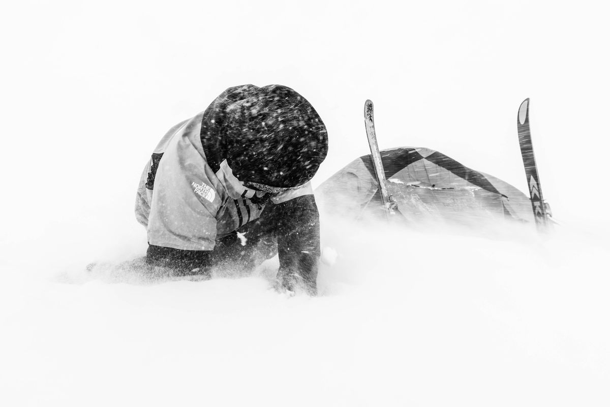Black and white skier digging out in deep powder